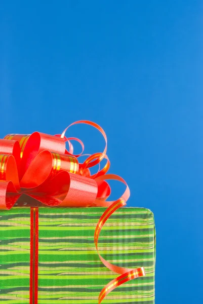 Boîte verte avec cadeau sur fond bleu — Photo