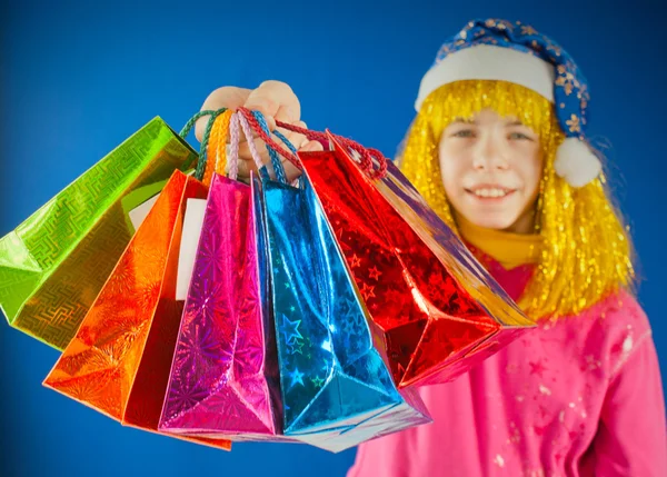 Дівчина-підліток тримає різні барвисті сумки на синьому фоні — стокове фото