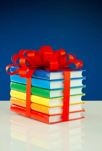 Stack of colorful books tied up with red ribbon — Stock Photo, Image
