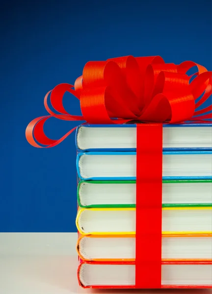 Stapel kleurrijke boeken vastgebonden met rood lint — Stockfoto