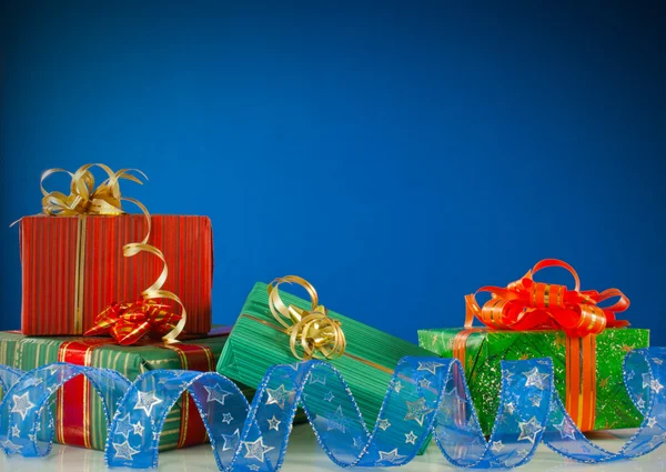Vánoční dárky na modrém pozadí — Stock fotografie