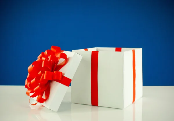 Boîte blanche avec cadeau sur fond bleu — Photo
