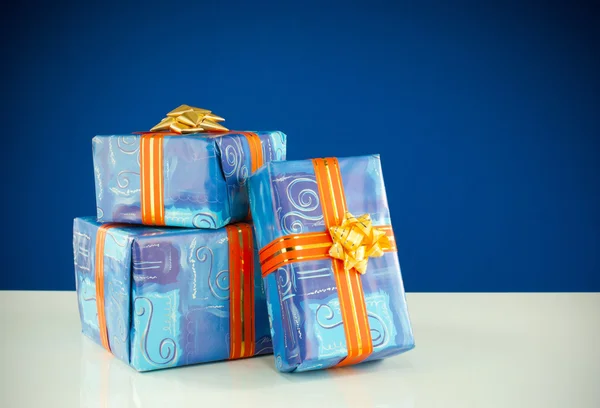 Weihnachtsgeschenke vor blauem Hintergrund — Stockfoto