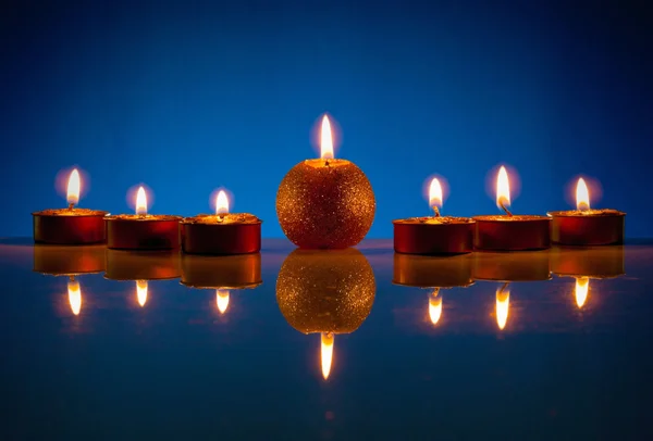 Sete velas acesas sobre fundo azul — Fotografia de Stock