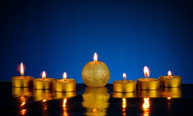 Seven burning candles over blue background clipart