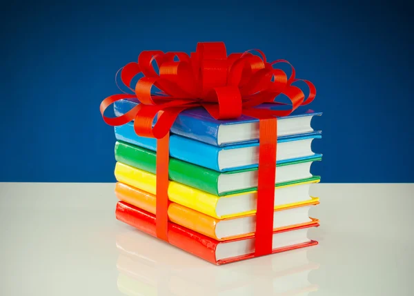 Stack of colorful books tied up with red ribbon — Stock Photo, Image