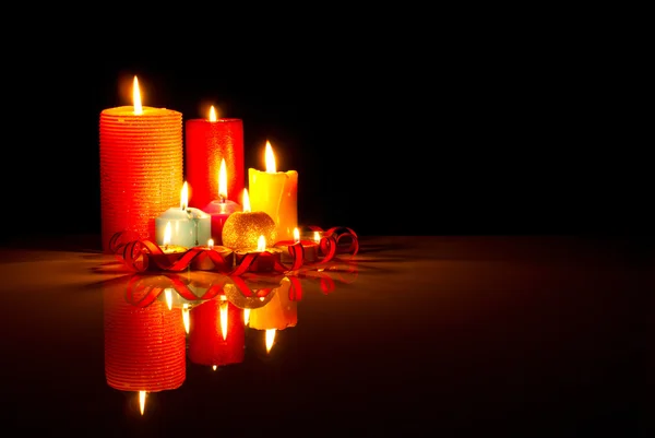 Een heleboel branden kleurrijke kaarsen tegen zwarte achtergrond — Stockfoto