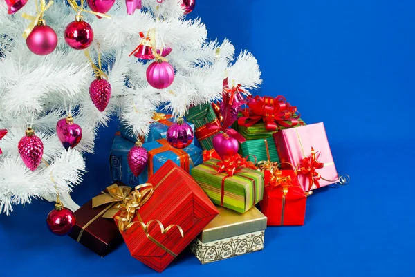 Heap dos presentes de Natal sob decorado branco evergreen t — Fotografia de Stock