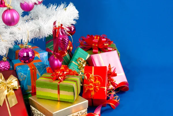 Kupie Bożego Narodzenia prezentuje pod urządzone biały t wiecznie — Zdjęcie stockowe