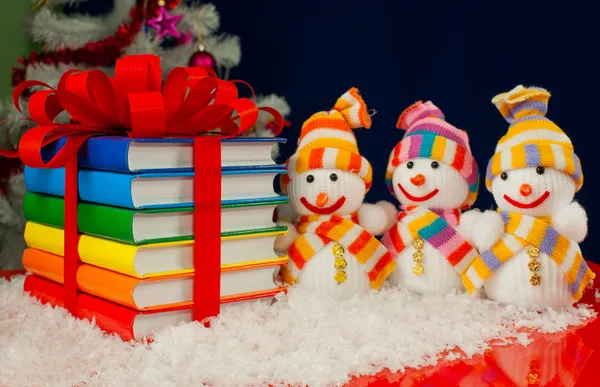 Üç snowme ve kırmızı kurdele ile bağlanmış renkli kitap yığını — Stok fotoğraf