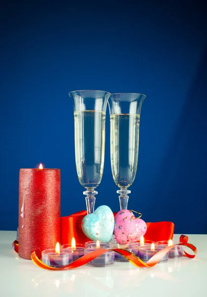 Два бокала вина и горящие свечи на голубом фоне — стоковое фото