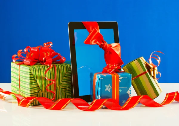 Подарки с планшетным ПК на синем фоне — стоковое фото