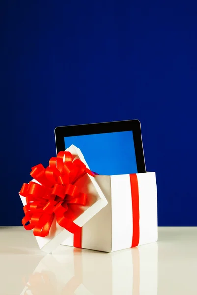 Tablette PC dans une boîte cadeau sur fond bleu — Photo