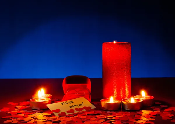 Два кольца и открытка с предложением руки и сердца с шестью свечами — стоковое фото
