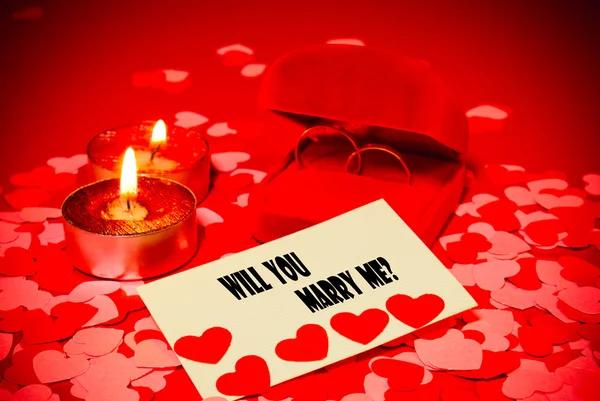 Карточка с брачным предложением и двумя кольцами и двумя свечами — стоковое фото