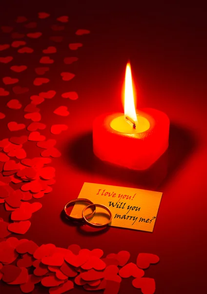 Dos anillos y una tarjeta con propuesta de matrimonio —  Fotos de Stock