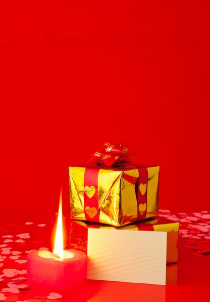 Presentes e vela em forma de coração ardente com cartão em branco — Fotografia de Stock