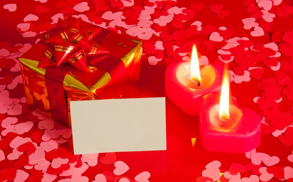 Presente y dos velas en forma de corazón con tarjeta en blanco —  Fotos de Stock