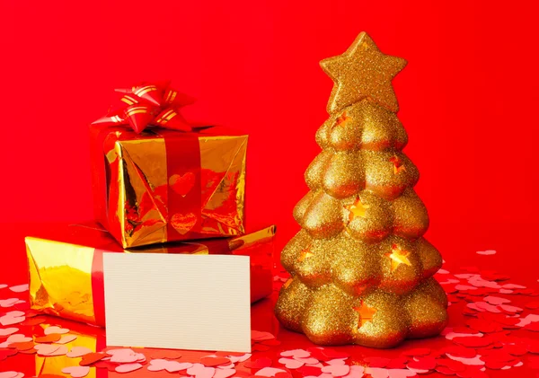 Dos regalos, tarjeta en blanco y árbol de hoja perenne dorado —  Fotos de Stock