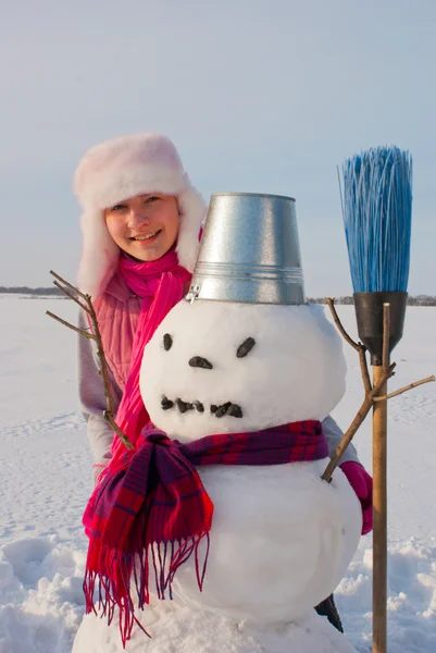 Девушка-подросток со снеговиком — стоковое фото