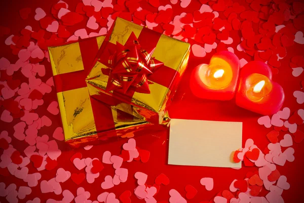 Presents and two heart shaped candles with blank card — Stock Photo, Image