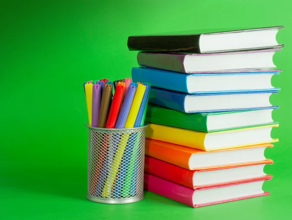 Stapel bunter Bücher und Steckdose mit Filzstiften — Stockfoto