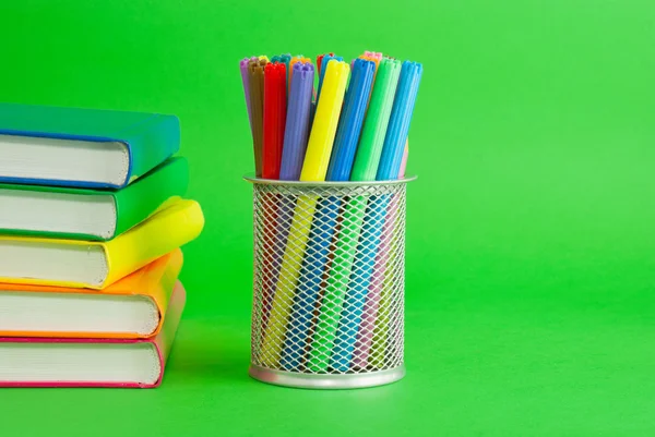 Stacks of colorful books and socket with felt pens — Stock Photo, Image