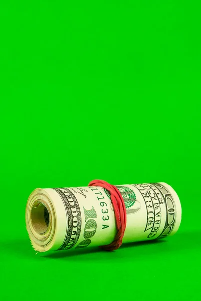 Roll of US dollars tied up with rubber — Stock Photo, Image