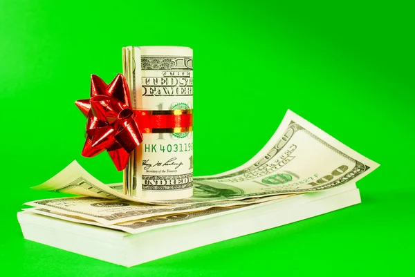 Roll of US dollars tied up with ribbon on the stack of bills — Stock Photo, Image