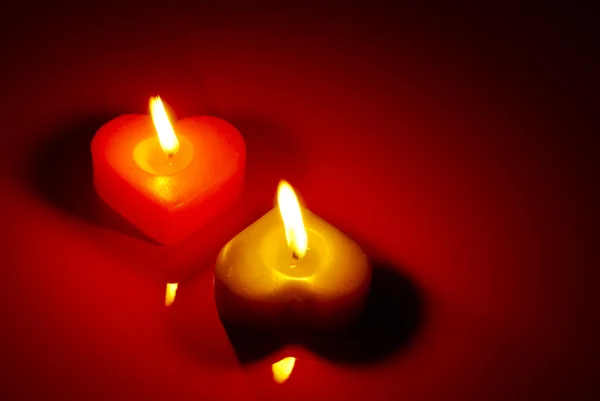 Две горящие свечи в форме сердца — стоковое фото