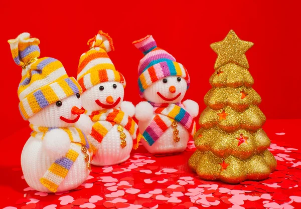 Três bonecos de neve com árvore perene dourada — Fotografia de Stock