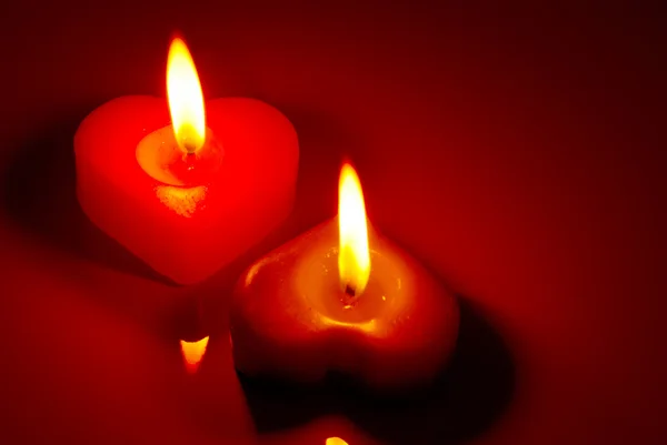 Две горящие свечи в форме сердца — стоковое фото