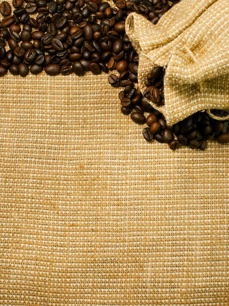 焼かれたコーヒー豆と黄麻布の背景 — ストック写真
