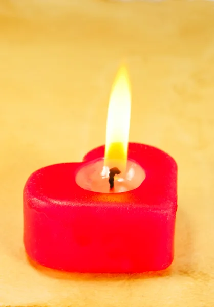 Hořící svíčka ve tvaru srdce — Stock fotografie