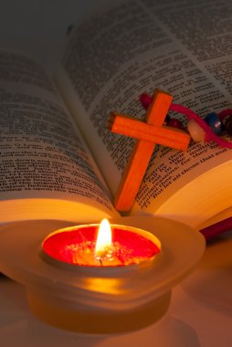 Open Bible with cross and burning candles clipart