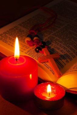 Open Bible with cross and burning candles clipart