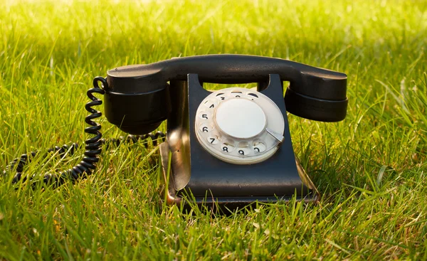 Retro stylu rotační telefon na trávě — Stock fotografie