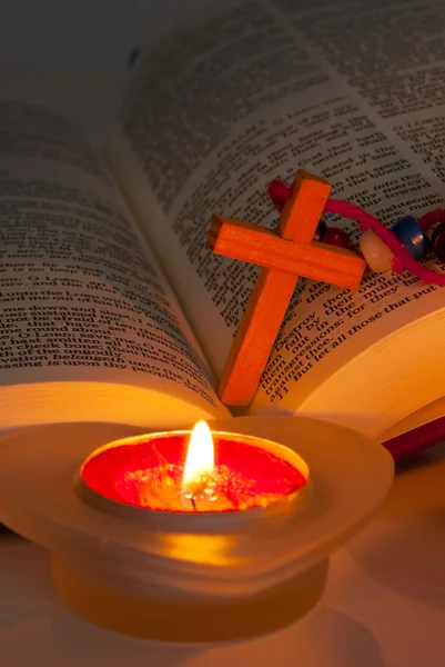 Bíblia aberta com cruz e velas acesas — Fotografia de Stock