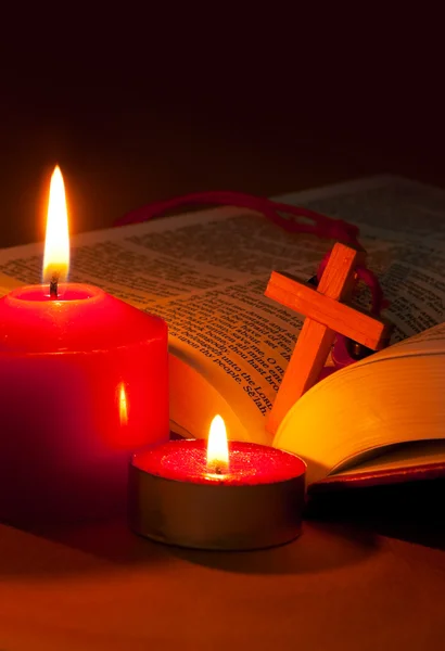 Offene Bibel mit Kreuz und brennenden Kerzen — Stockfoto