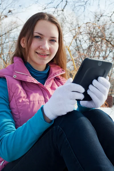 Menina adolescente com leitor de e-book em um parque — Fotografia de Stock