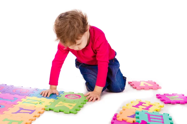 Ragazza carina risolvere puzzle alfabeto — Foto Stock