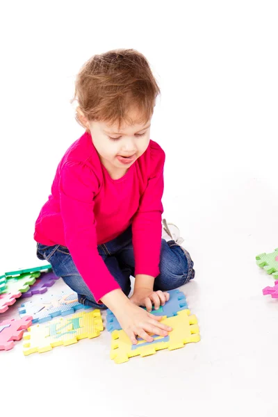 Pouco bonito menina resolver quebra-cabeça alfabeto — Fotografia de Stock
