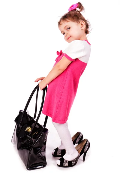 Klein meisje probeert op haar moeder accessoires en schoenen — Stockfoto
