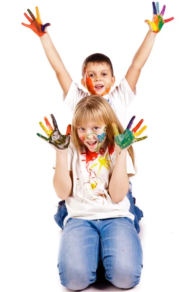 Crianças felizes com mãos pintadas em tintas coloridas — Fotografia de Stock
