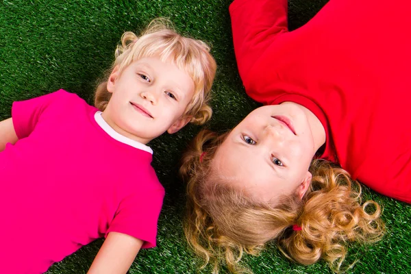 Группа счастливых детей, лежащих на зеленой траве — стоковое фото