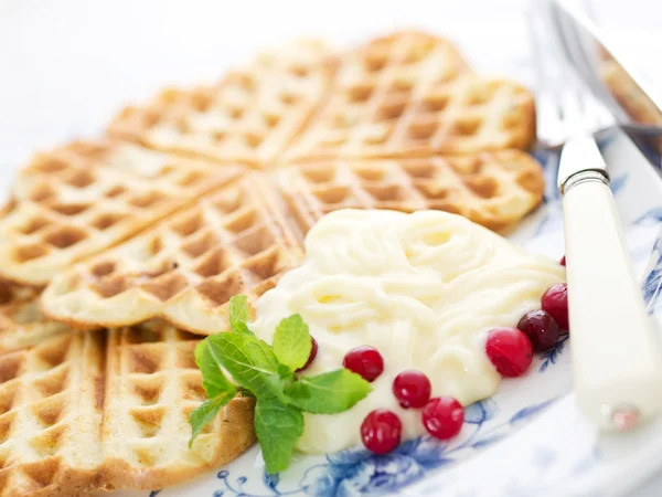 Sweet wafer hearts on dish with cream, berries and mint Royalty Free Stock Images
