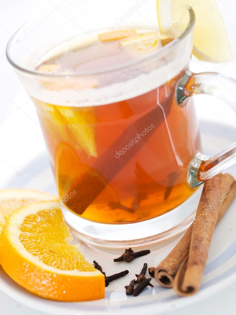 Black tea in glass cup with orange slices and cinnamon