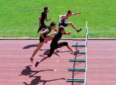 Boys on the 110 meters hurdles race clipart