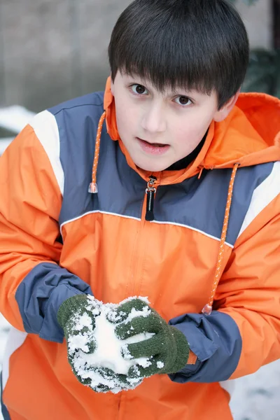 Jongen hebben plezier met sneeuwbal strijd winter buiten — Stockfoto