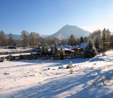 Famous russian tourist village Zamulta in winter in Uimon Valley, Altai mou clipart